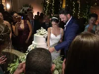 Casal cortando o bolo no casamento